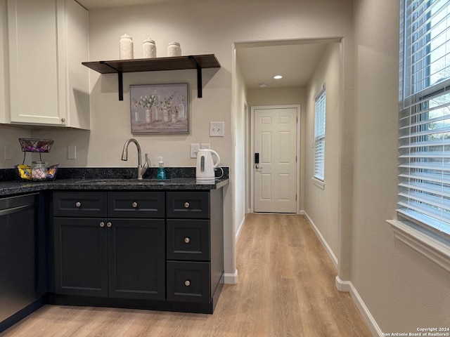 kitchen featuring dishwasher, white cabinetry, sink, and light hardwood / wood-style flooring