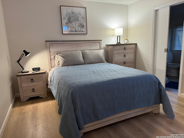 bedroom featuring light hardwood / wood-style flooring and ensuite bath