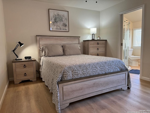 bedroom with wood-type flooring and ensuite bath