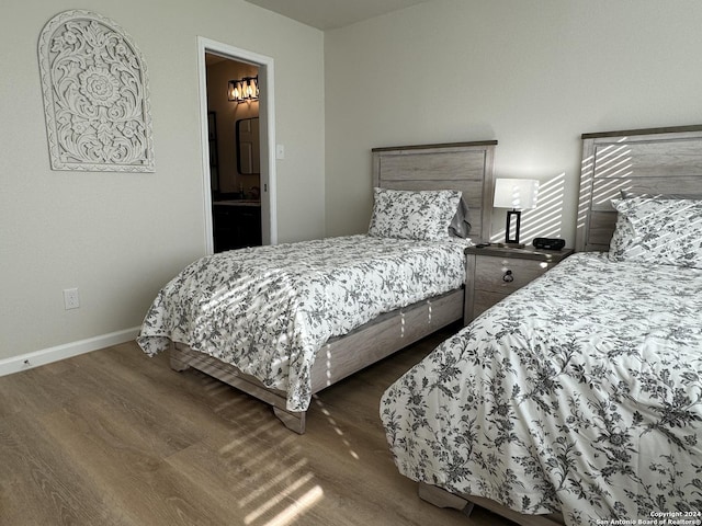 bedroom with dark hardwood / wood-style flooring and ensuite bath