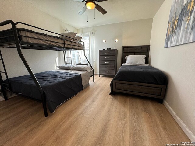 bedroom with light hardwood / wood-style floors and ceiling fan