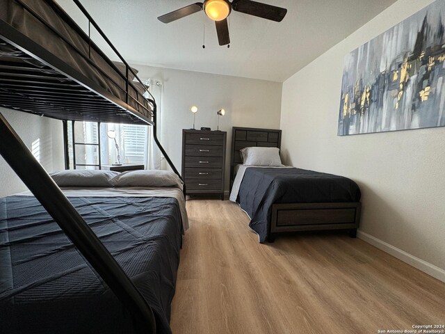 bedroom with light hardwood / wood-style floors and ceiling fan