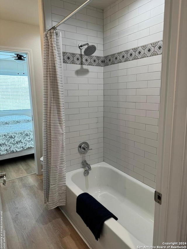 bathroom with hardwood / wood-style floors and shower / tub combo with curtain