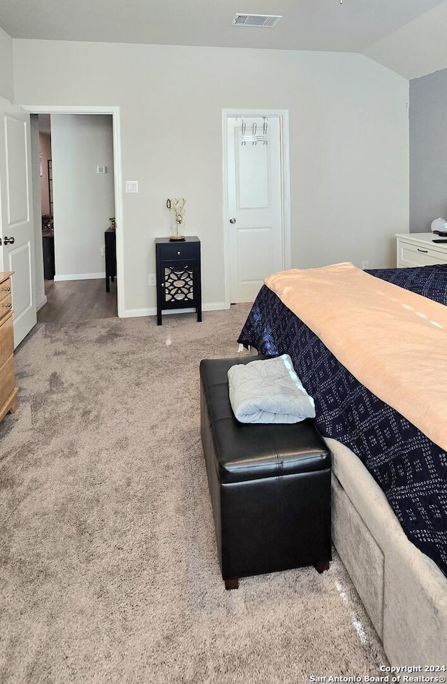 carpeted bedroom featuring lofted ceiling