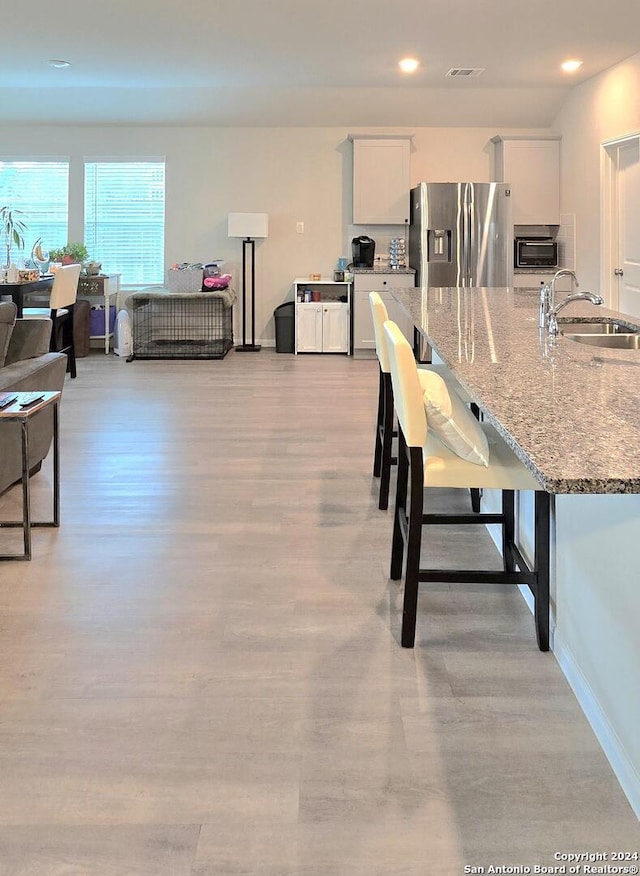 dining space with light wood-type flooring and sink