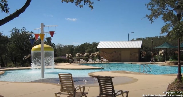 view of swimming pool with pool water feature and an outbuilding