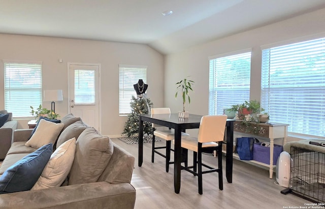 dining room with light hardwood / wood-style floors and lofted ceiling