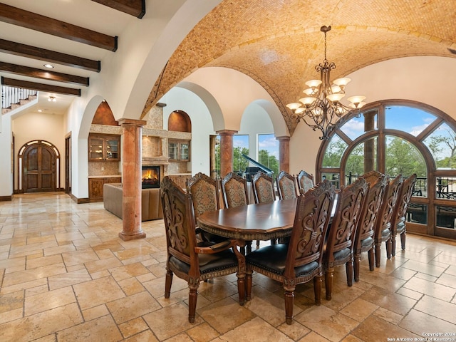 dining area with beam ceiling, ornate columns, and a notable chandelier