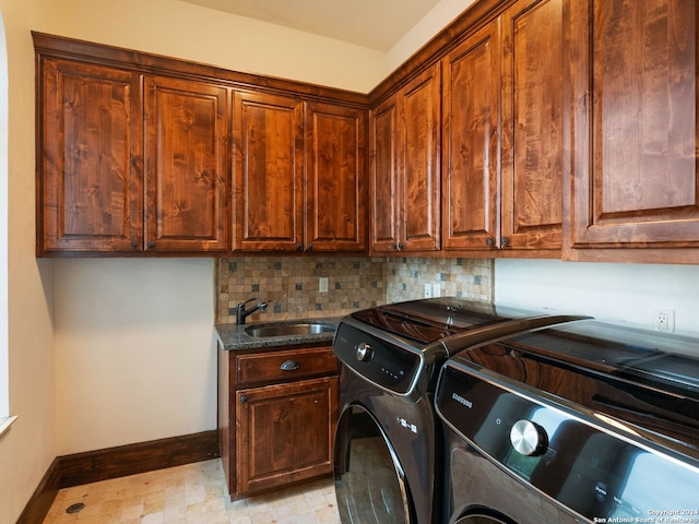 clothes washing area featuring sink, cabinets, and independent washer and dryer