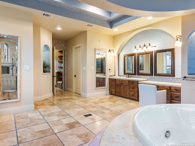 bathroom featuring vanity, a bathtub, and a tray ceiling