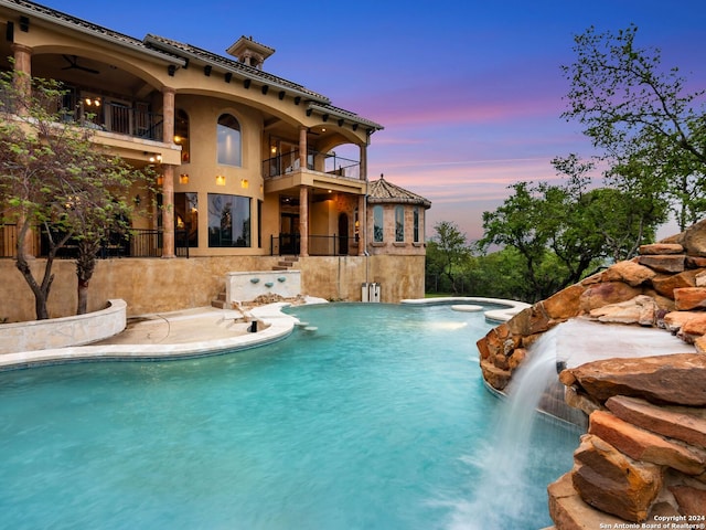 pool at dusk with pool water feature