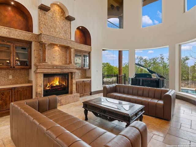 living room featuring a high ceiling, plenty of natural light, and a premium fireplace