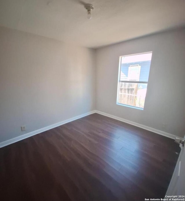 spare room featuring dark wood-type flooring