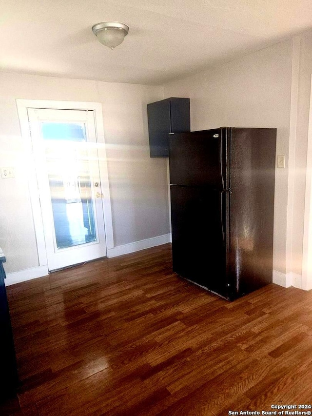 kitchen with black refrigerator and dark hardwood / wood-style floors