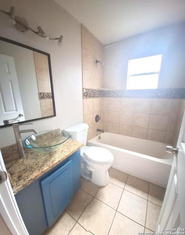 full bathroom with tile patterned floors, vanity, toilet, and tiled shower / bath combo