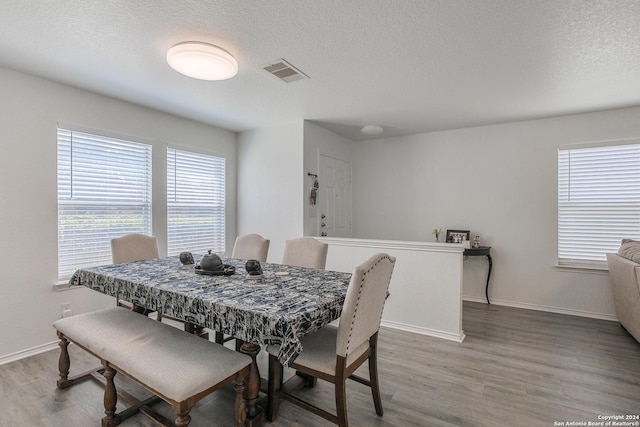 dining area featuring hardwood / wood-style floors and a textured ceiling