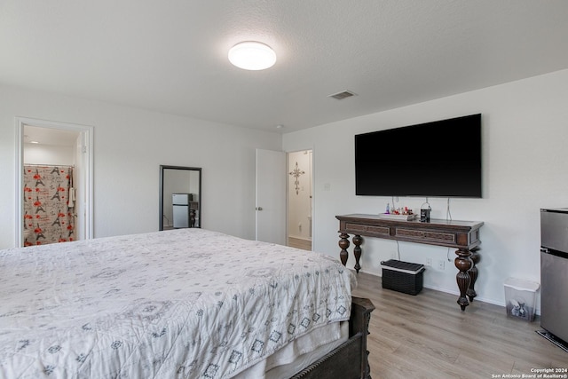 bedroom with a textured ceiling and light hardwood / wood-style flooring