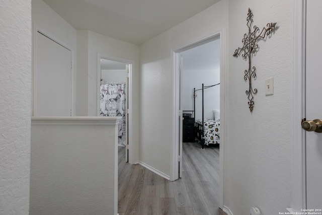 hallway with light hardwood / wood-style floors