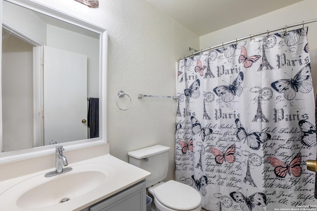 bathroom featuring vanity, curtained shower, toilet, and a textured ceiling