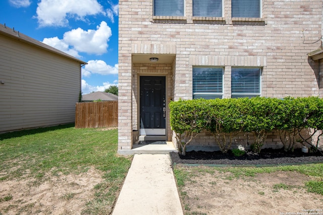 property entrance with a lawn