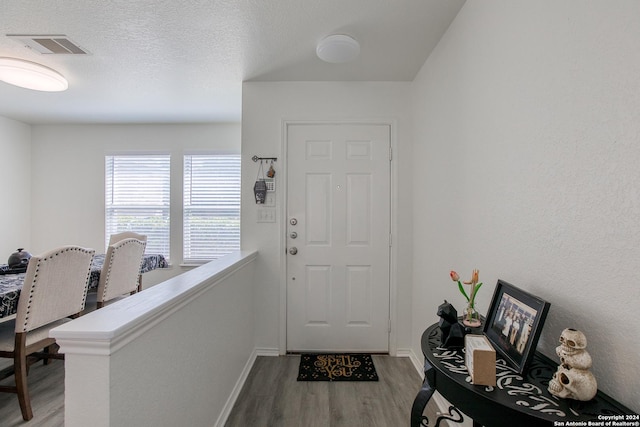 entryway featuring wood-type flooring and a textured ceiling