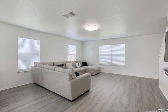 living room with light hardwood / wood-style floors and a textured ceiling