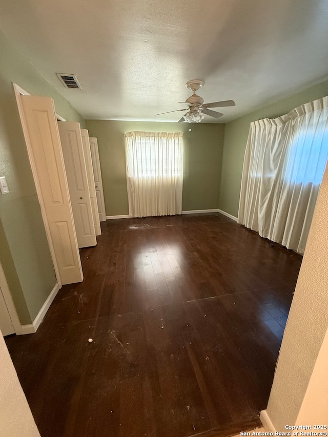 empty room featuring ceiling fan and dark wood-type flooring