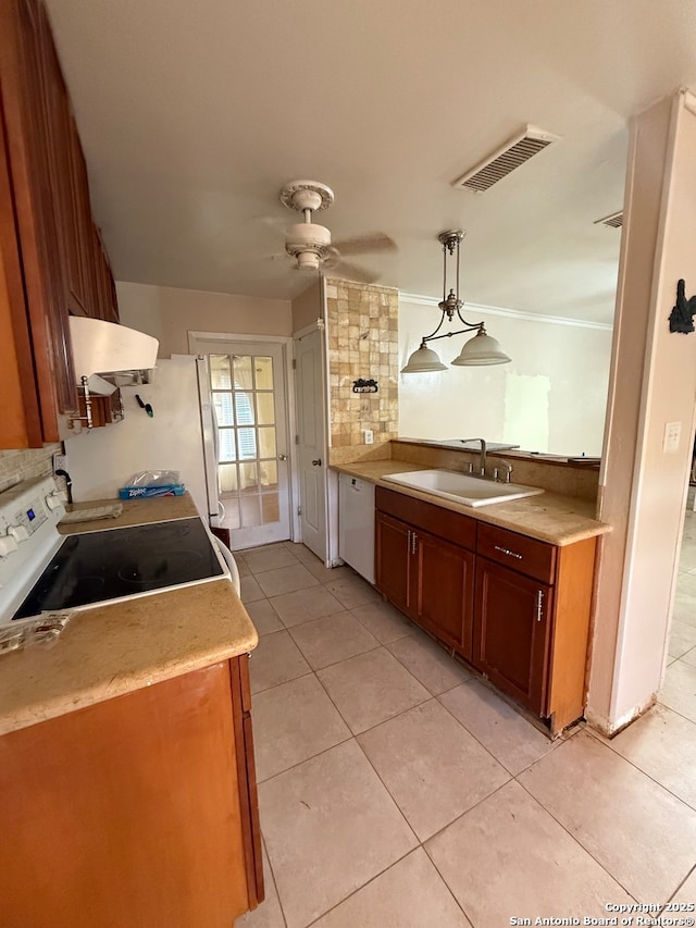 kitchen featuring sink, stove, white dishwasher, pendant lighting, and light tile patterned floors