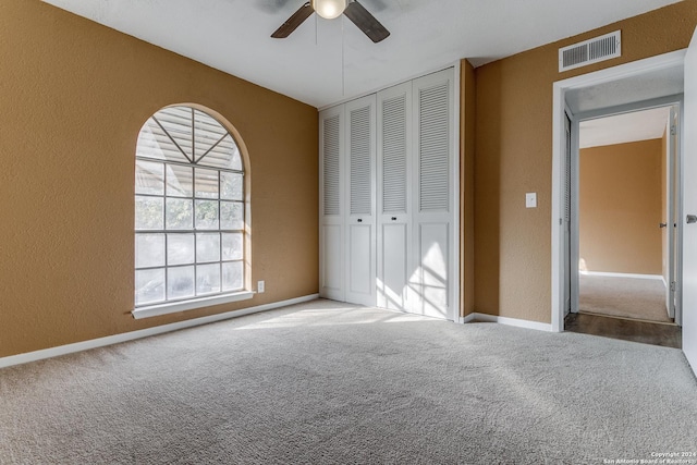 unfurnished bedroom featuring carpet flooring, a closet, and ceiling fan