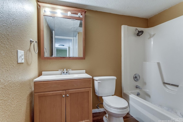 full bathroom with vanity, shower / tub combination, hardwood / wood-style flooring, toilet, and a textured ceiling