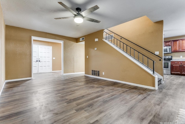 unfurnished living room with hardwood / wood-style floors and ceiling fan