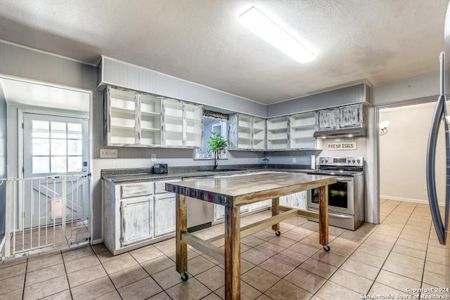 kitchen featuring a textured ceiling, light tile patterned flooring, sink, and appliances with stainless steel finishes