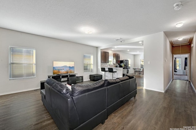 living room featuring a textured ceiling and dark wood-type flooring