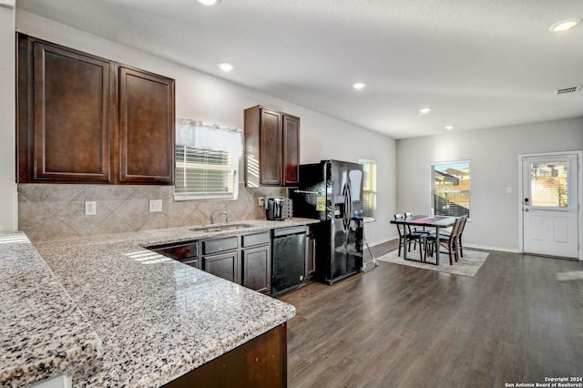 kitchen with backsplash, dark brown cabinets, sink, black appliances, and dark hardwood / wood-style floors