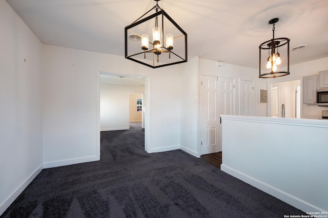 interior space featuring dark carpet and a notable chandelier