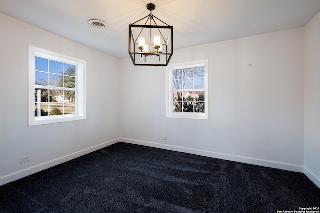 unfurnished room featuring a notable chandelier and carpet floors