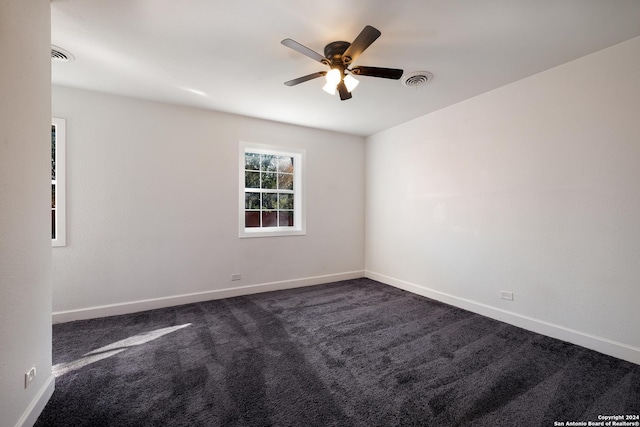 unfurnished room with dark colored carpet and ceiling fan