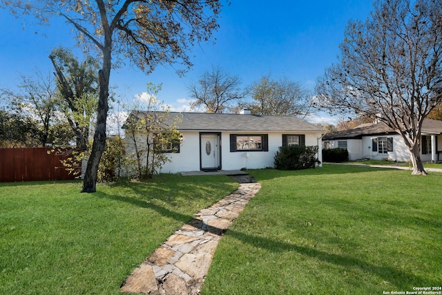 ranch-style home featuring a front lawn