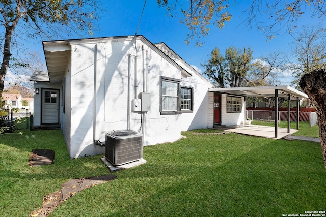 back of house with a lawn and central AC unit