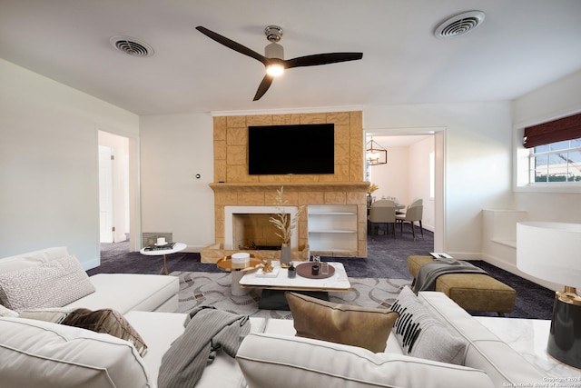 living room with ceiling fan, a fireplace, and carpet