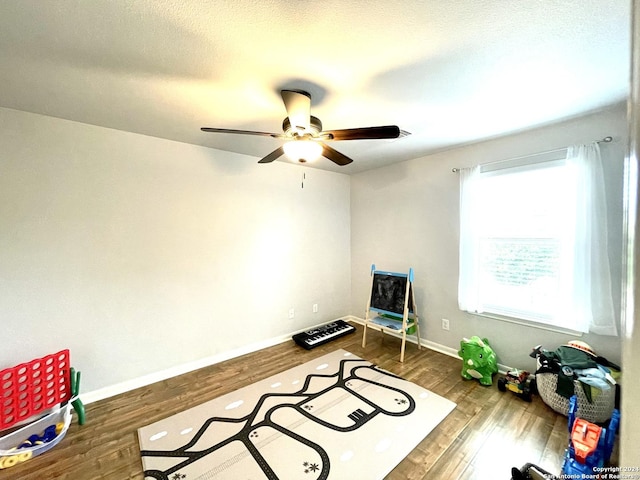 exercise area featuring dark hardwood / wood-style floors and ceiling fan