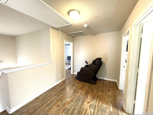 sitting room with a textured ceiling and dark wood-type flooring