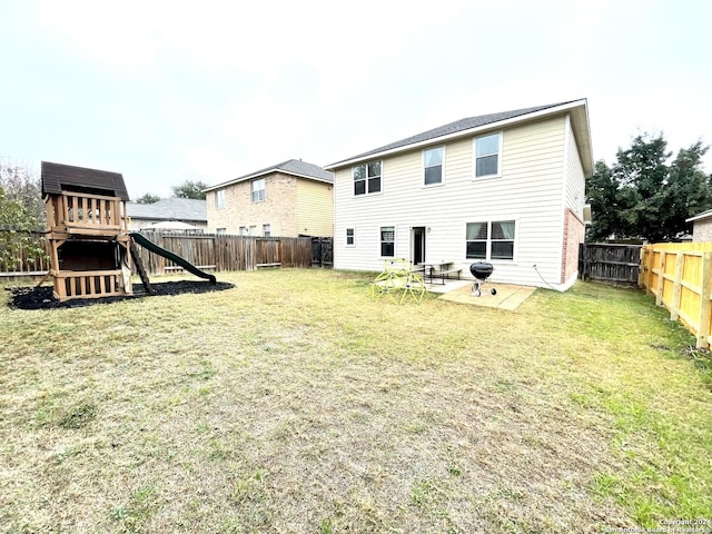 rear view of property with a lawn and a playground