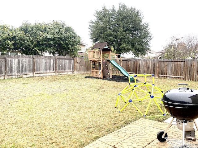 view of playground featuring a patio area and a yard