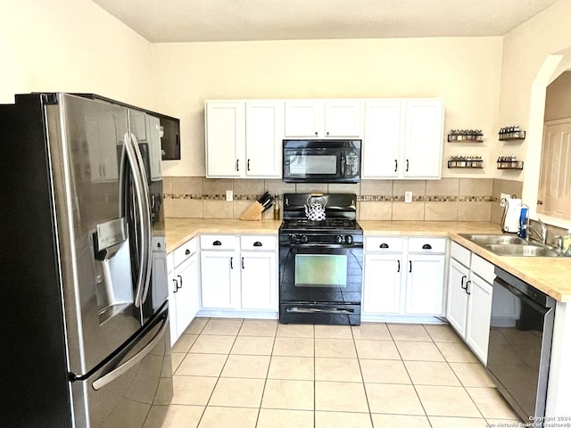 kitchen featuring black appliances, white cabinetry, and sink