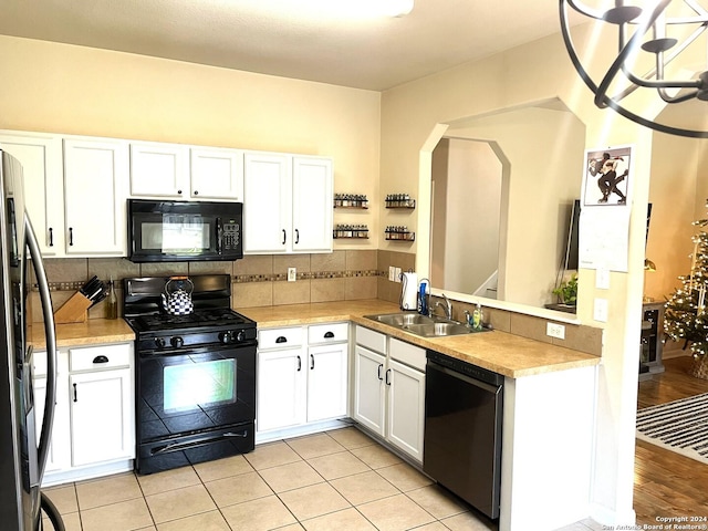 kitchen featuring backsplash, sink, black appliances, light tile patterned floors, and white cabinetry