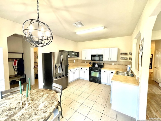 kitchen with sink, white cabinets, black appliances, and decorative light fixtures