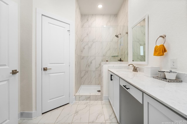 bathroom featuring a tile shower and vanity