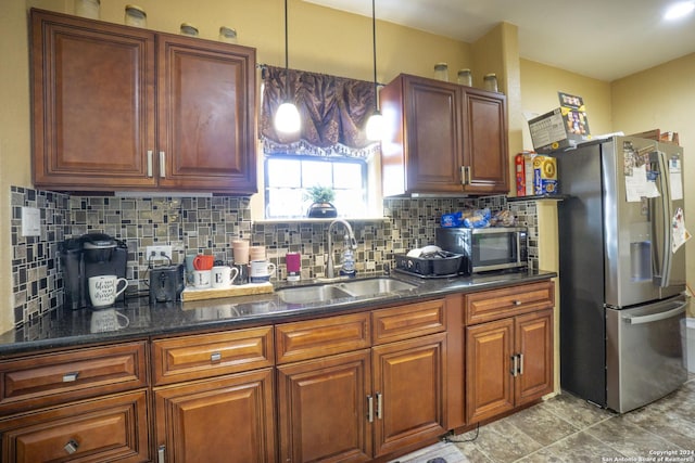 kitchen featuring appliances with stainless steel finishes, decorative light fixtures, tasteful backsplash, and sink