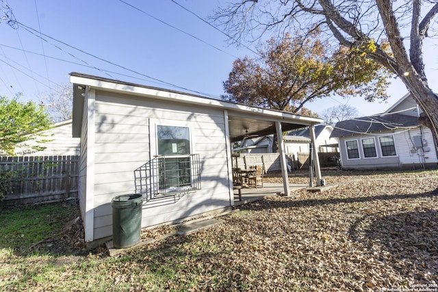 rear view of property with ceiling fan and a patio area